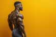 © artdolgov - Strong and defined white male bodybuilder poses confidently, highlighting his impressive back muscles and physique in a fitness studio with a bright yellow wall.