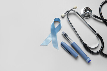 Wall Mural - Awareness ribbon with lancet pen and stethoscope on light background. Diabetes concept