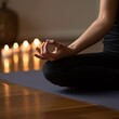 © Ninja in Pajamas - A peaceful person meditating on a yoga mat with hands in a mudra gesture. Lit candles and a softly lit background evoke a calming atmosphere, perfect for yoga, meditation, and relaxation