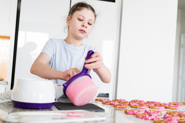 Wall Mural - Young Chef Prepares Chocolate-Covered Treats in Sunny Kitchen