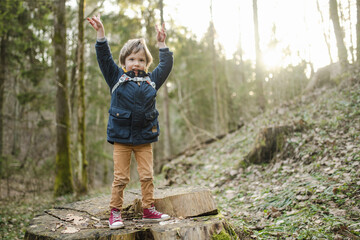 Adorable little boy having fun during a hike in the woods on beautiful sunny spring day. Active family leisure with kids.