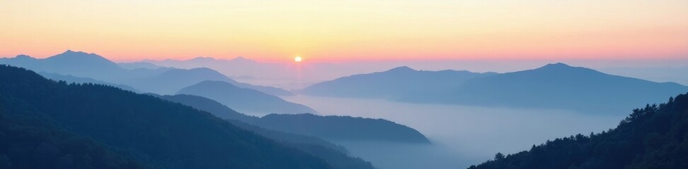 Wall Mural - a misty morning over a mountain range with a hint of color in the sky, mist, serene atmosphere