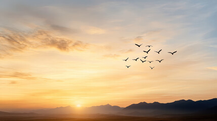 Sticker - flock of birds flying across orange sunset over mountains, creating dreamy atmosphere