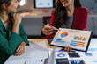 © amnaj - Businesswomen analyzing financial charts and discussing company strategy