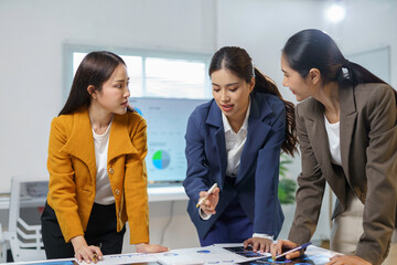 Wall Mural - businesswomen analyzing financial charts and discussing marketing strategies in modern office