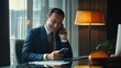 © Chandlerlikes - Successful financier investor works inside office at work, businessman in business suit uses telephone near window, man smiles and reads good news online from smartphone.