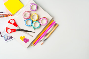 Wall Mural - Crafting supplies arranged for creative projects on a light background with scissors, colorful tape, and various pens