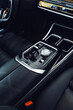 © fotofabrika - Interior view of a luxury car showcasing a sleek center console and gear shift during a sunny afternoon drive
