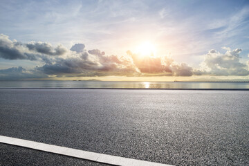 Wall Mural - Asphalt road and coastline with sky clouds nature landscape at sunset. Outdoor road background.