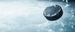 © meristock - Frozen hockey puck gliding above the icy surface with a cool blue background highlighting motion and dynamic energy in sports.