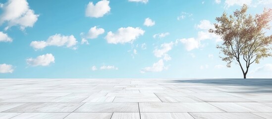 Poster - Serene landscape with a single bare tree on the right side against a clear blue sky and fluffy white clouds, featuring a smooth light gray tiled surface.