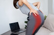 © doucefleur - Woman experiencing sciatic nerve pain from buttock to leg due to poor posture while working at computer