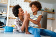 © NDABCREATIVITY - Portrait of happy black woman and her cute preteen daughter having fun together at home