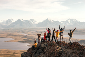 Aufkleber - Large group of tourists diverse people hikers are standing at mountain top at winner poses with open raised arms and enjoys achievement