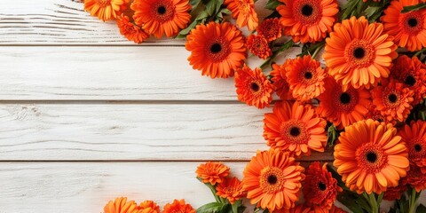 Fototapete - Vibrant orange gerbera flowers elegantly cascading across the top left corner of a white wooden backdrop with green leaves enhancing the composition