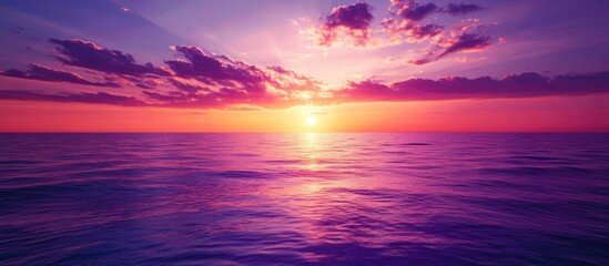 Fototapete - Vibrant sunset sky with purple pink and orange hues reflecting over the tranquil sea creating a serene background with ample space for text.