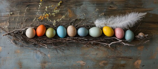 Colorful Easter eggs in a nest with feathers and willow branches on a rustic wooden background for a festive holiday theme