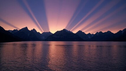 Aufkleber -  A serene sunset over a mountain landscape with warm golden light reflecting on a calm lake.