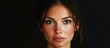 © StockKing - Striking portrait of a woman with olive skin and dark hair showcasing deep brown eyes and soft contours against a solid black background