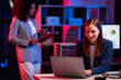 © MrAshi - White businessman and African woman work as a team and use laptop tablet for night research. Data analysis results Comparing and planning with digital technology