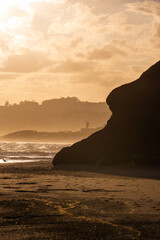 Wall Mural - silhouette of headland under the golden sunset light.
