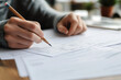 © Татьяна Евдокимова - Close up of hands holding a pencil while filling out a multiple choice test form on a desk, emphasizing focus and attention to detail