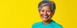 © Gadiel - Happy mature woman smiling against yellow background. (1)