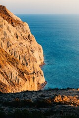 Wall Mural - Golden Coastal Cliff Over Blue Sea