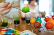 © MNStudio - Pretty teenage girl dyeing Easter eggs at home. Child painting colorful eggs for Easter hunt. Kid getting ready for Easter celebration.