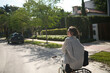 © Connect Images - Woman in striped shirt rides a bicycle on a sunny suburban street with lush greenery, Miami, Florida, USA
