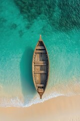 Wall Mural - Aerial View of a Wooden Boat on Turquoise Ocean Water Near Sandy Beach Shoreline with Gentle Waves