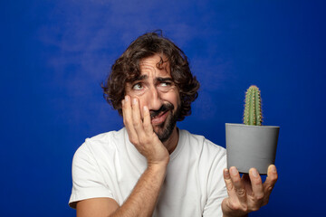 Sticker - young adult bearded man holding a cactus house plant