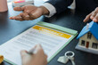 © Kield KD - Two people are sitting at a table with a piece of paper in front of them. One of them is pointing at the paper. There are two calculators on the table, one on the left and one on the right