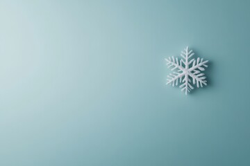 Poster - A single silver snowflake rests on a pastel blue background, showcasing its detailed icy design as it catches the light, perfect for seasonal decoration
