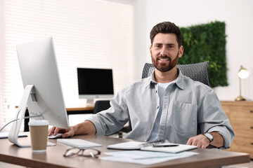 Wall Mural - Man working on computer at table in office