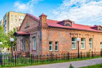 Wall Mural - A brick building with a red roof and white trim