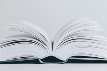 capture close-up of open book with soft lighting highlighting pages emphasizing textures and invitin