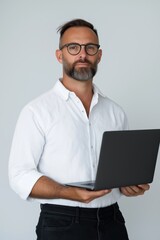 Wall Mural - A man wearing glasses and a white shirt is holding a laptop. He has a serious expression on his face