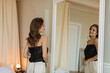 © RooM The Agency - Stylish young woman standing in front of a mirror in her bedroom looking at her reflection