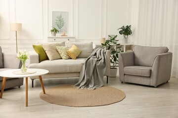 Poster - Stylish furniture and houseplants in light living room. Interior design