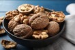 © New Africa - Fresh walnuts in bowl on blue table, closeup