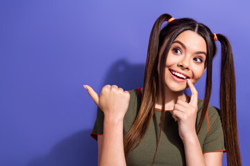 Wall Mural - Smiling young woman gesturing playfully against a violet background