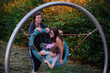 © Иванна Емельянова - Woman supervising two children on a swing at the park