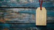 © mahamad - A colorful price tag with a red string loop hangs from a rustic wooden background, awaiting special offer details.