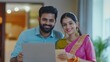 © Johannes - Happy indian family couple shoppers customers using laptop computer doing ecommerce shopping together at home. Smiling husband and wife consumers holding credit card buying online, making e payments.