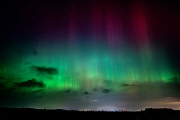 colorful aurora borealis, beautiful beams of northern lights in the night sky against the background