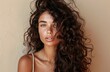© Photopia - Woman with dark curly hair, Natural beauty, Studio portrait, Sun kissed skin, Healthy hairstyle, Confident feminine style, Fashion look, Minimal warm background