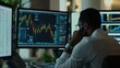 © STwul - Analyst reviewing stock market data at night in modern office