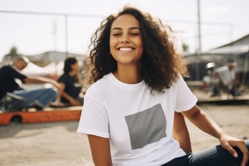 Wall Mural - Portrait of a beautiful young african american woman with curly hair sitting on the beach.