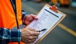 © Vadym - Construction worker checks safety checklist on clipboard. Worker wears high-visibility vest. Focuses on compliance on job site. Ensuring safety protocols followed. Documentation of procedures for